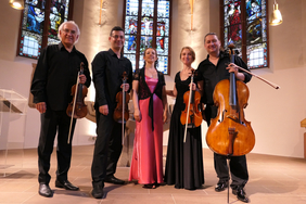 Das Franck Piano Quintett: Die Musikerinnen und Musiker stehen nebeneinander in einer Kirche