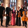 Das Franck Piano Quintett: Die Musikerinnen und Musiker stehen nebeneinander in einer Kirche