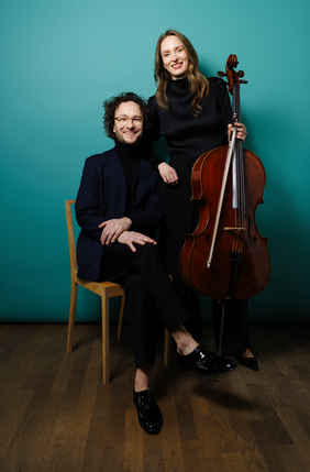 Martin Helmchen sitzt auf einem Stuhl, neben ihm steht Marie-Elisabeth Hecker und hält ihr Cello in der Hand